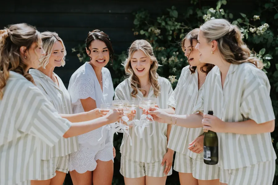 Bride and bridesmaids toasting together in matching pyjamas before the wedding