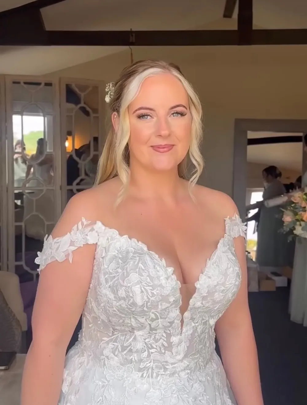 Bride in a lace wedding gown with soft glam makeup on her wedding morning